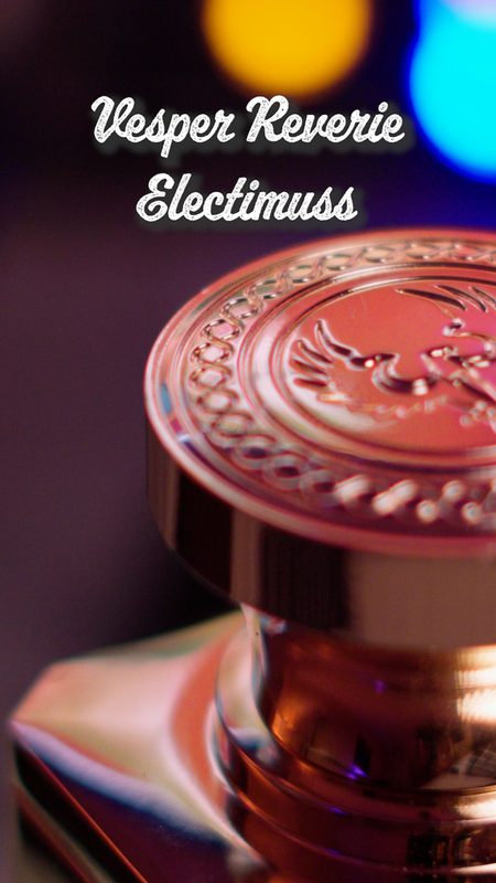 Macro detail of the engraved metal cap of Electimuss Vesper Reverie with gold and blue bokeh — luxury fragrance product photography